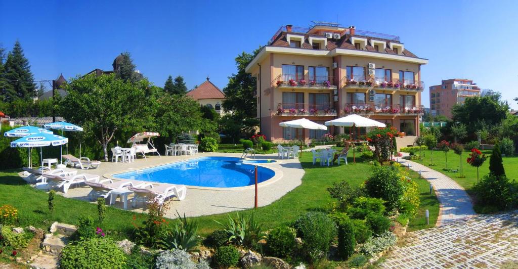 a hotel with a swimming pool in front of a building at Family Hotel Vega in Saints Constantine and Helena