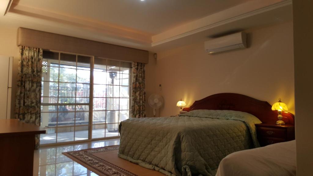 1 dormitorio con cama y ventana grande en Vimal's Homestay, en Perth