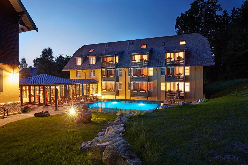 a large house with a swimming pool in front of it at Ferien Residenz Bergfried in Hinterzarten