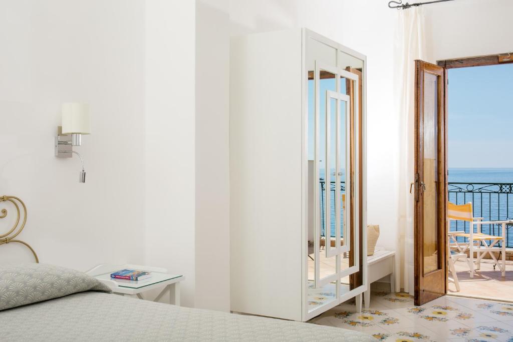 a bedroom with a bed and a view of the ocean at Hotel Pupetto in Positano