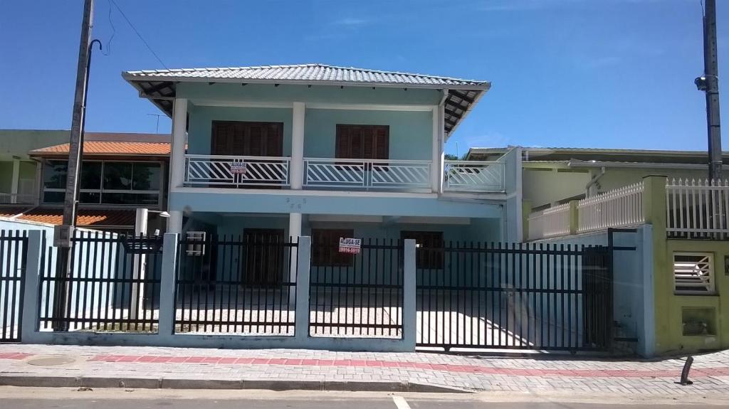 a white house with a fence in front of it at Casa Porto Belo in Porto Belo