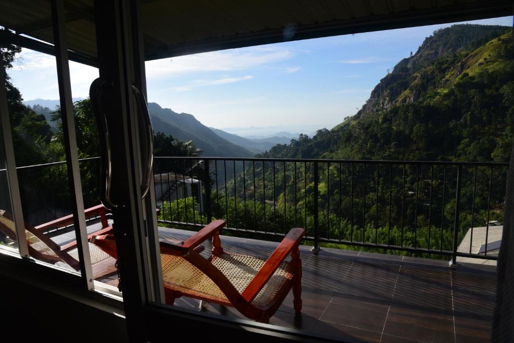a room with a balcony with a view of the mountains at Seven Heaven in Ella