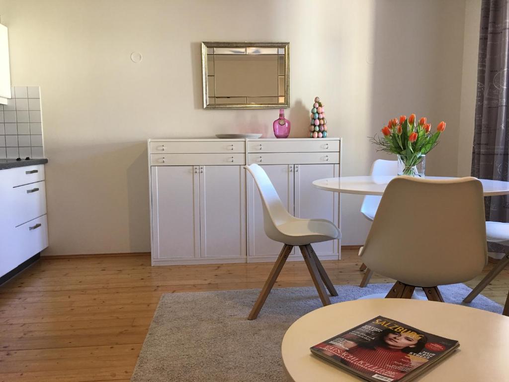 a living room with a table and chairs and a kitchen at Wohnung Schloss Mondsee in Mondsee