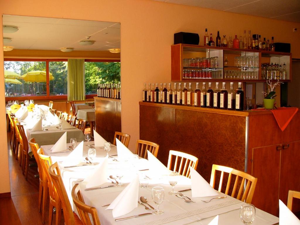 ein Esszimmer mit weißen Tischen und Weinflaschen in der Unterkunft Hotel Rigi Klösterli in Kulm