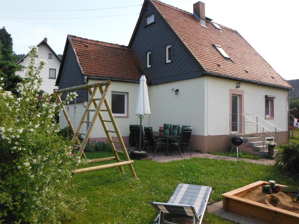 una casa con parque infantil en el patio en Ferienhaus Sonneneck, en Sebnitz