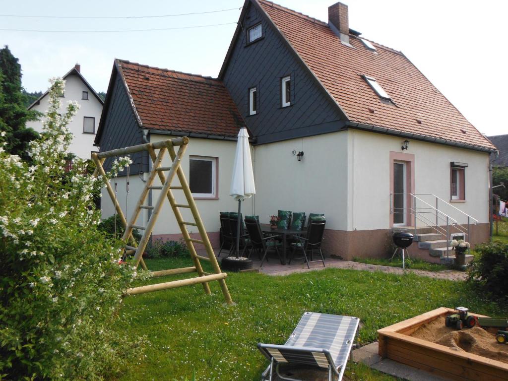 a house with a playground in the yard at Ferienhaus Sonneneck in Sebnitz
