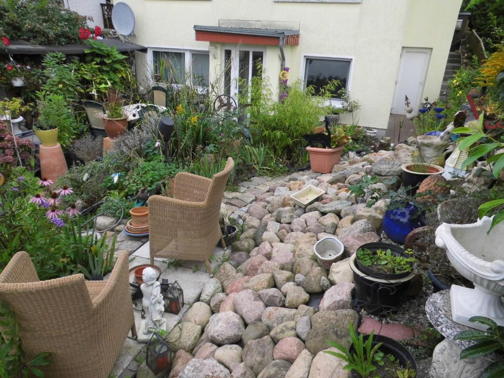 un jardin avec des rochers, des chaises et des plantes dans l'établissement Charmante Ferienwohnung, à Plön