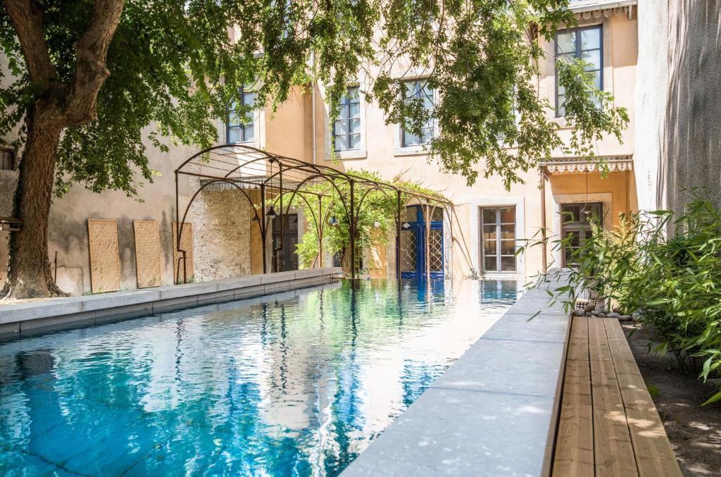 une piscine en face d'un bâtiment dans l'établissement B&B Les chambres d'Aimé, à Carcassonne