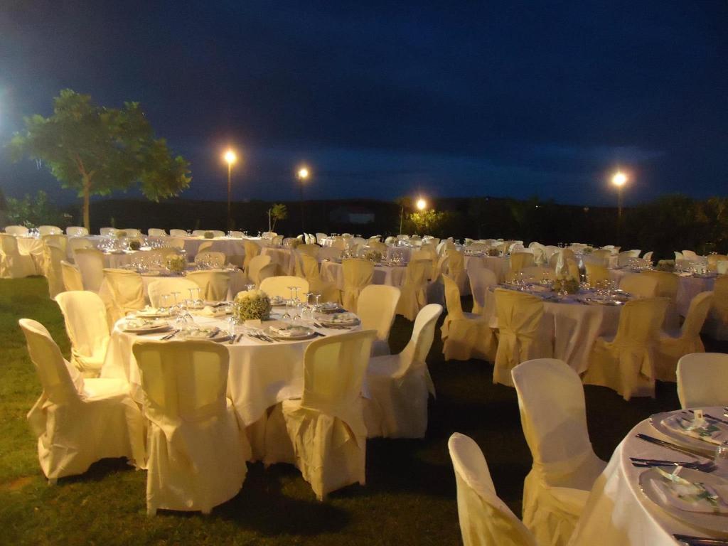 a large group of tables and chairs with white table cloths at Il Vigneto Resort in Menfi