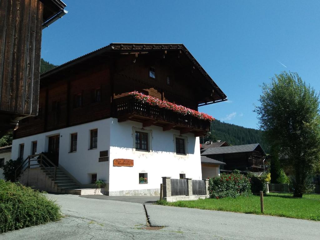 Una casa blanca con un techo con flores. en Haus Antonius, en Sankt Lorenzen im Lesachtal