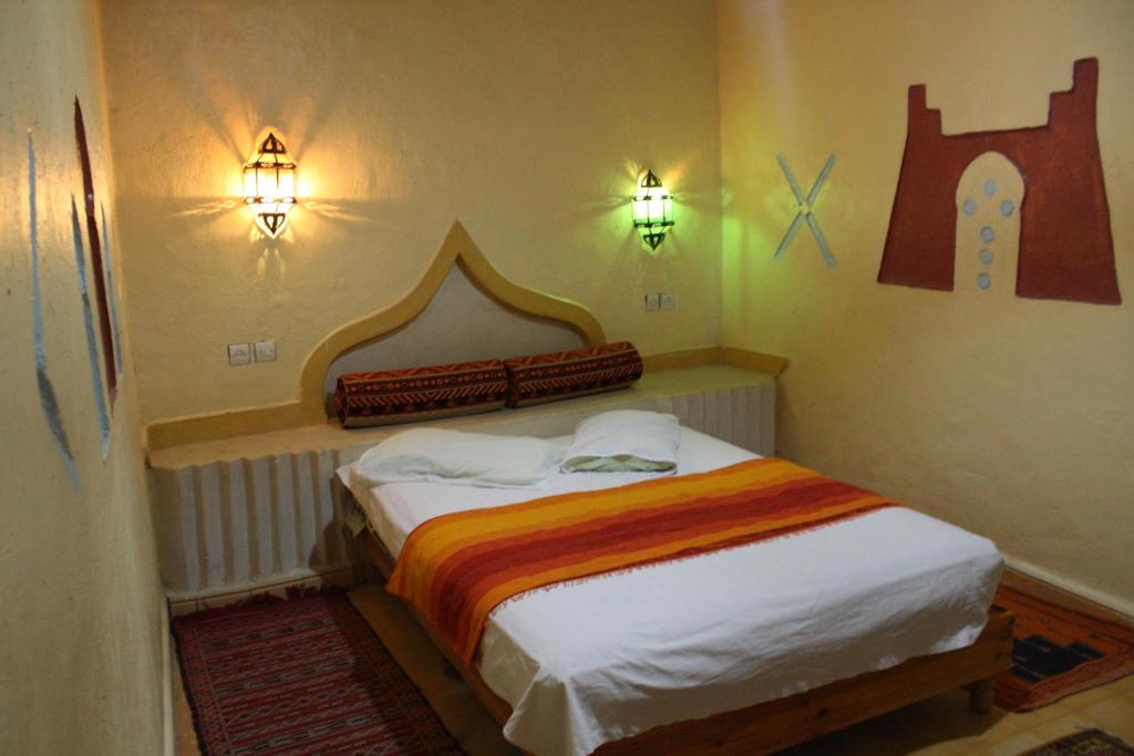 a small bedroom with a bed in a room at Chez Belkacem in Merzouga
