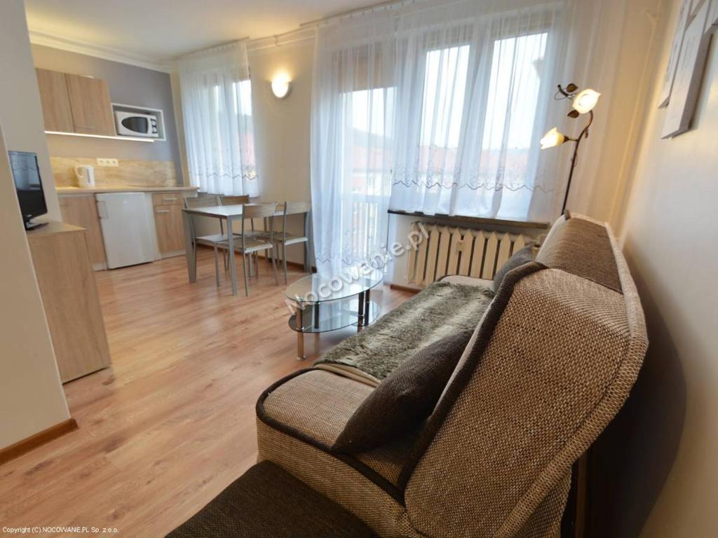 a living room with a couch and a dining room at Apartament Ustrzyki in Ustrzyki Dolne