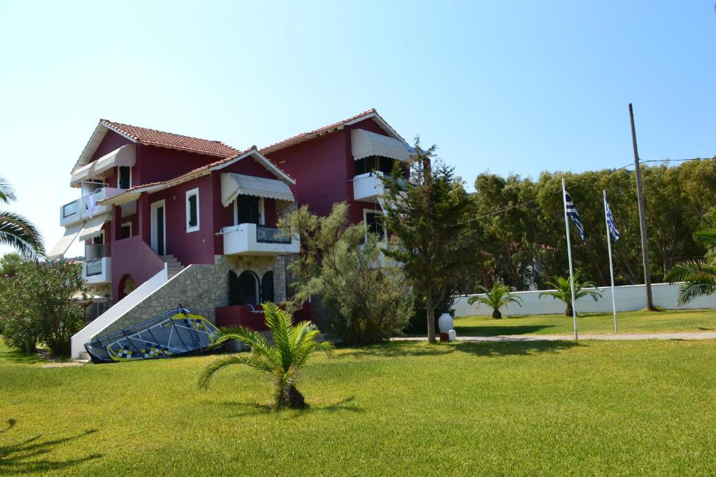 una casa con un césped verde delante de ella en Villa Ioli en Lefkada