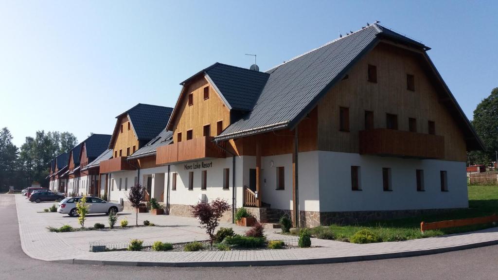 eine Reihe von Häusern mit Autos auf einem Parkplatz in der Unterkunft Apartmán Pohoda Nová Pec in Nová Pec