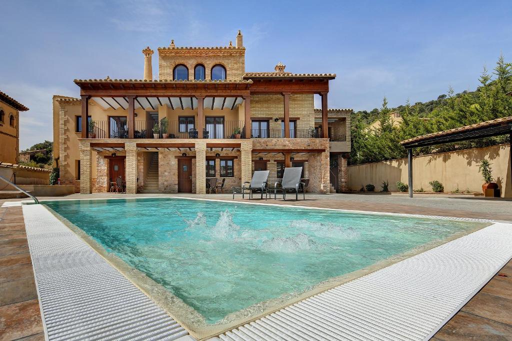 a house with a swimming pool in front of it at El Portal de Alquezar in Alquézar