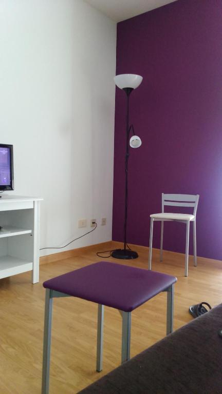 salon z fioletową ścianą, stołem i lampką w obiekcie Apartamento Gallego VUT-PO-02510 w mieście Sanxenxo