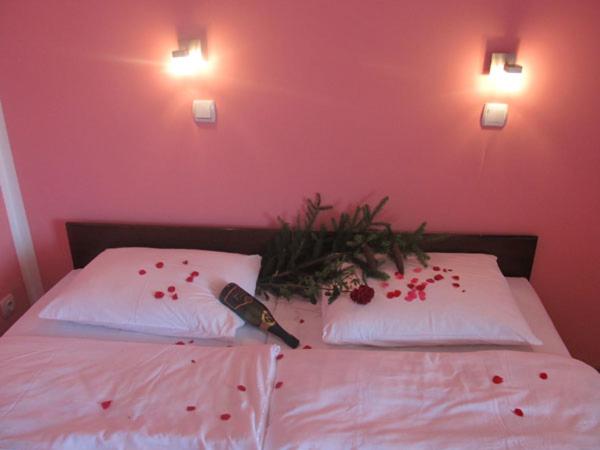 a bedroom with a white bed with flowers on the pillows at Apartments Markoni in Zlatibor