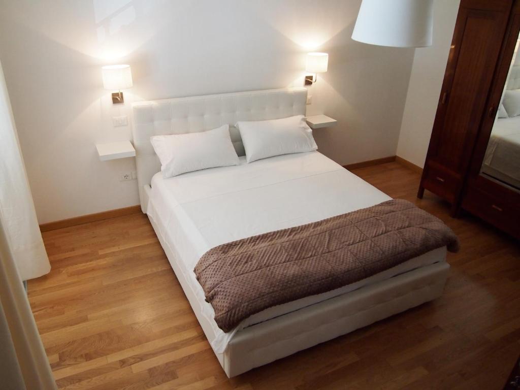 a white bed in a room with two lamps at IL PORTICO - La Spezia to go 5Terre in La Spezia