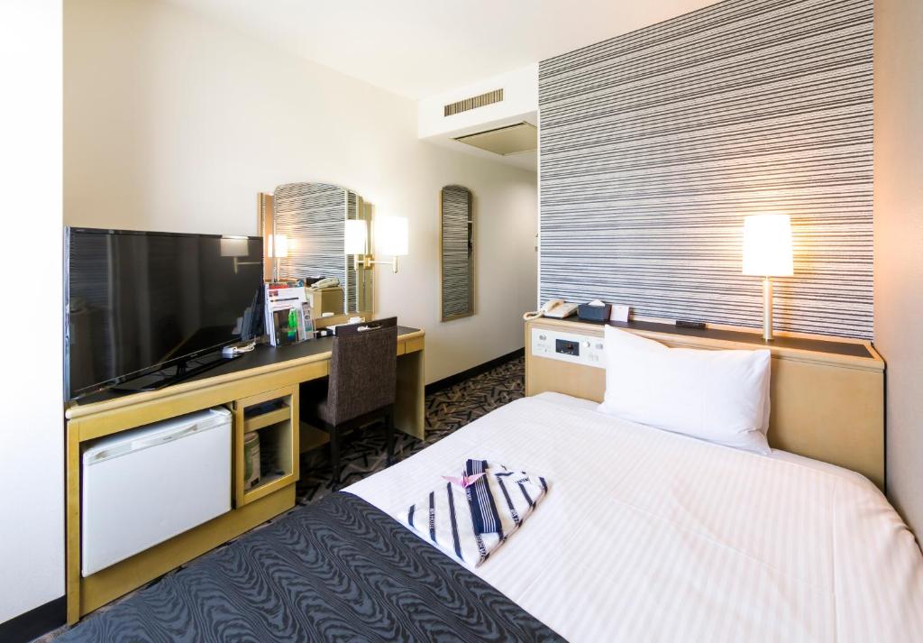 Postel nebo postele na pokoji v ubytování APA Hotel Fujichuo