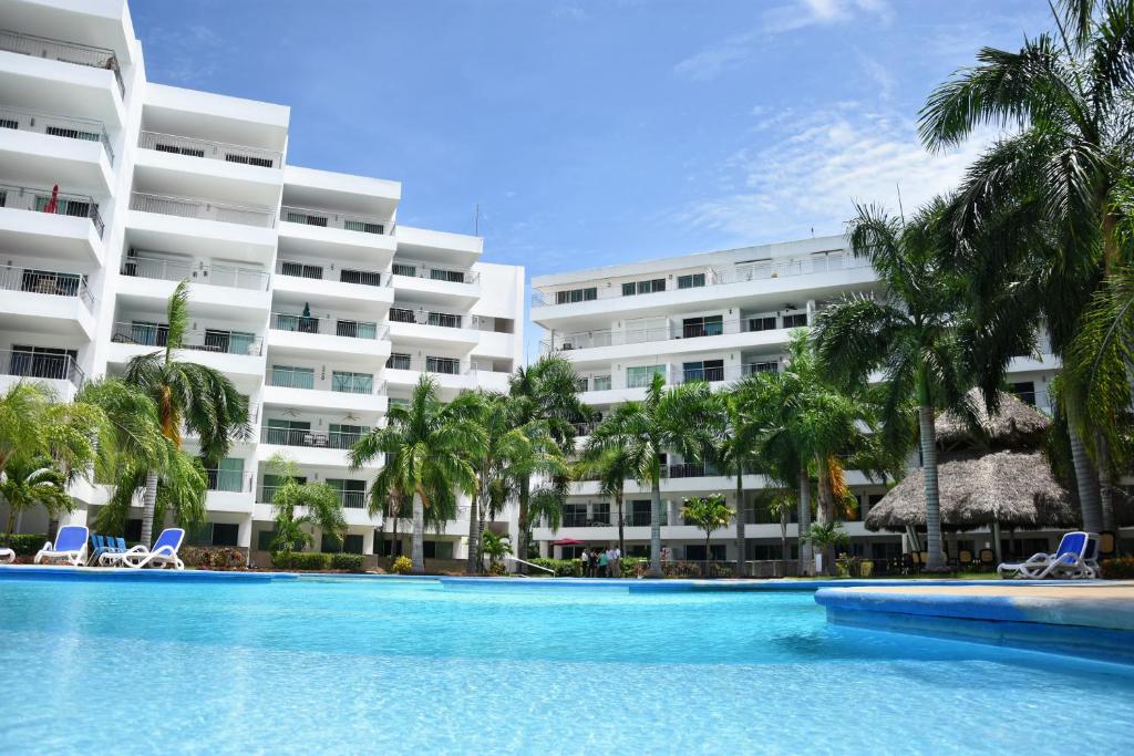 a swimming pool in front of a large building at Departamento en Marina in Mazatlán