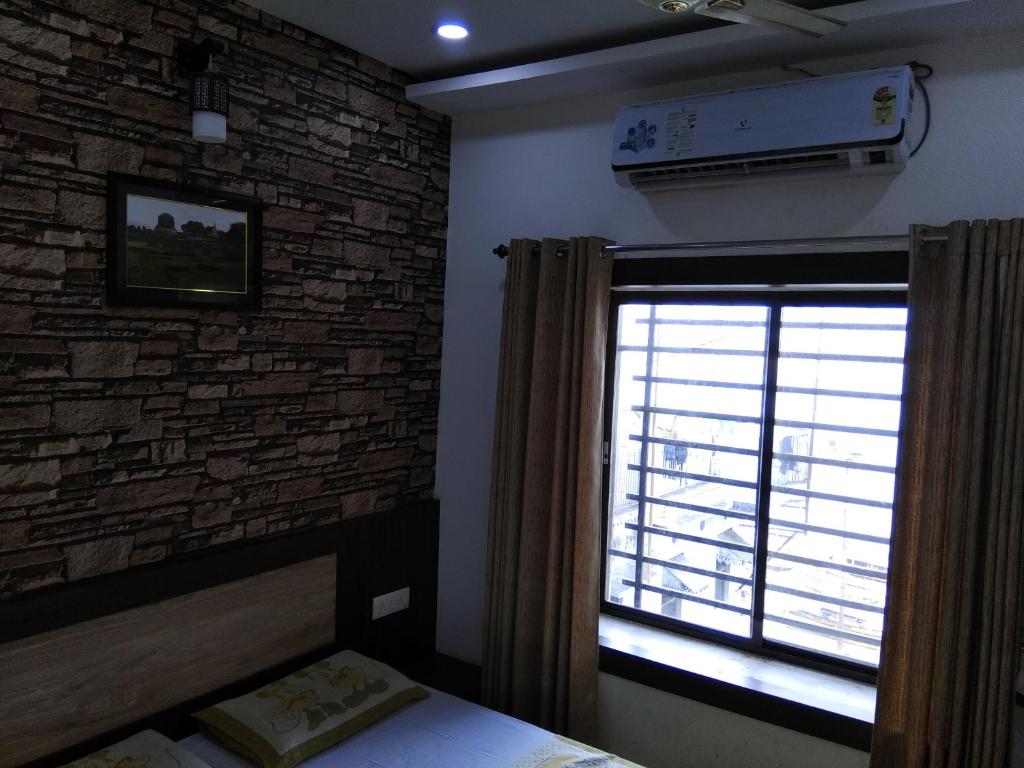 - une chambre avec un mur en briques et une fenêtre dans l'établissement Alakhnanda Guest House, à Varanasi