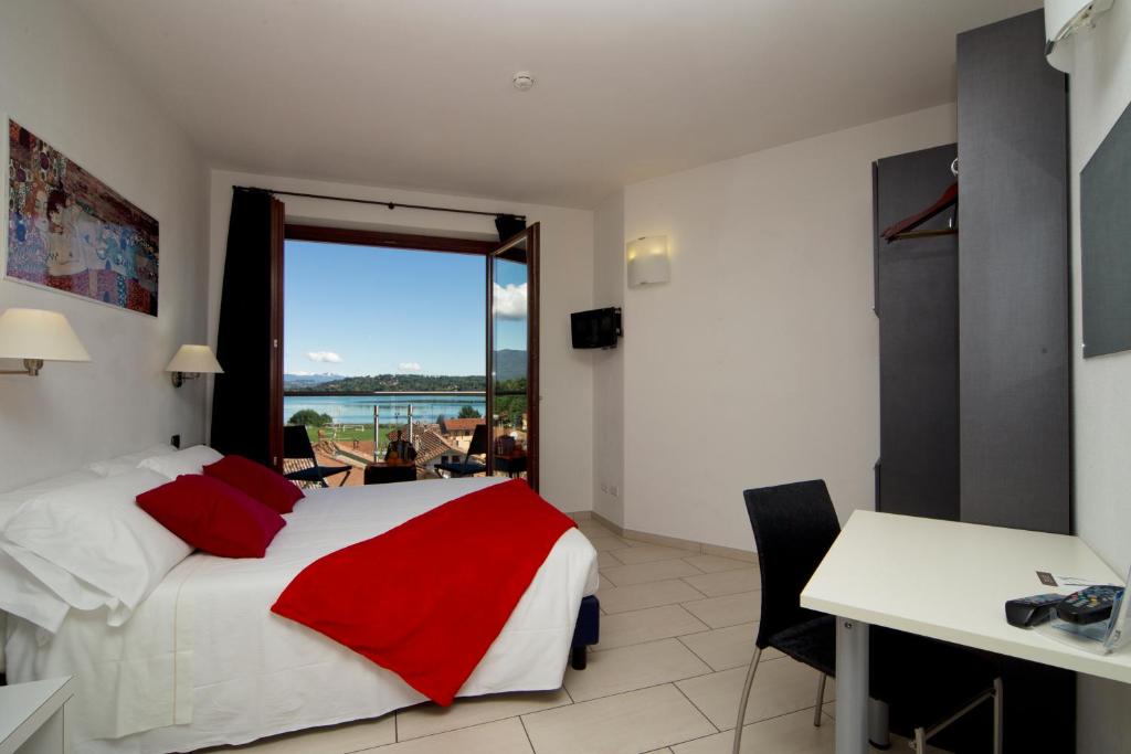 een slaapkamer met een bed, een bureau en een raam bij Hotel La Locanda in Cadrezzate
