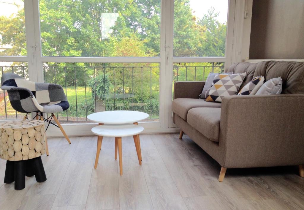 a living room with a couch and a table at Safari chic in Lille