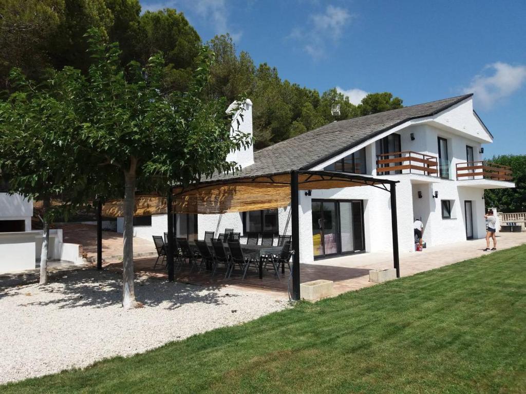 a white house with a table and chairs and a tree at Casa Carmen in Alcanar