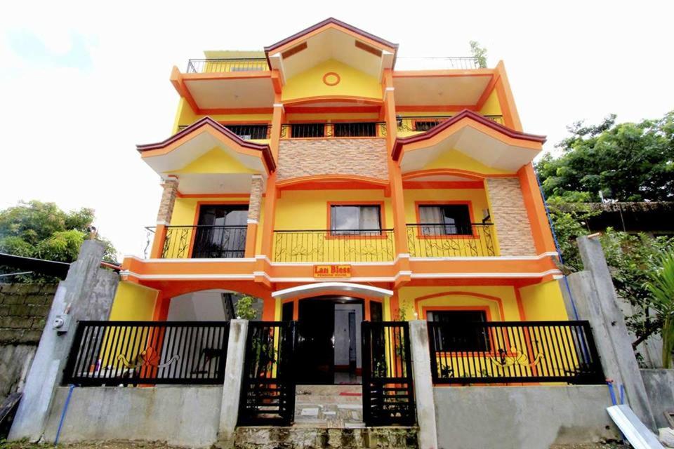 Casa de color naranja y amarillo con balcón en Lan Bless Pension House en Corón