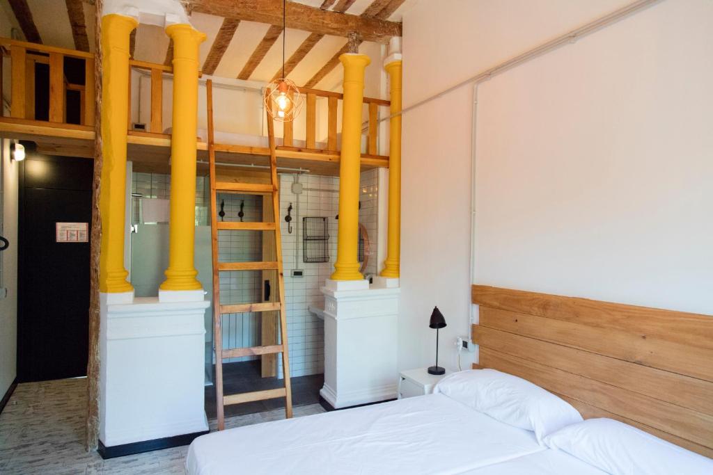 Green River Hostel في كوينكا: غرفة نوم بسرير وأعمدة صفراء