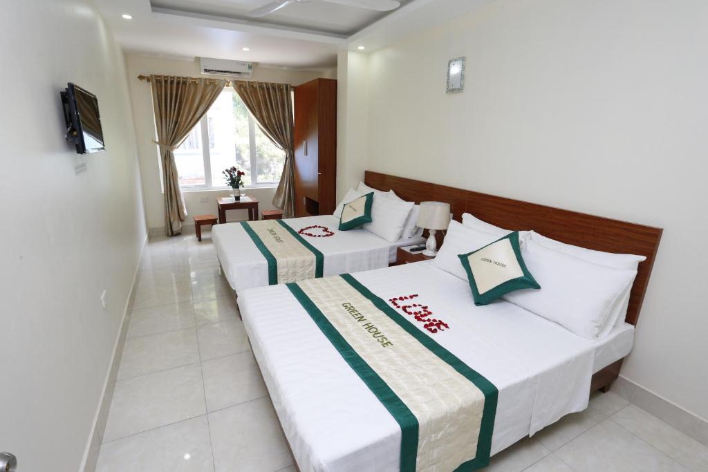 a hotel room with two beds and a television at catba sunrise hotel in Cat Ba