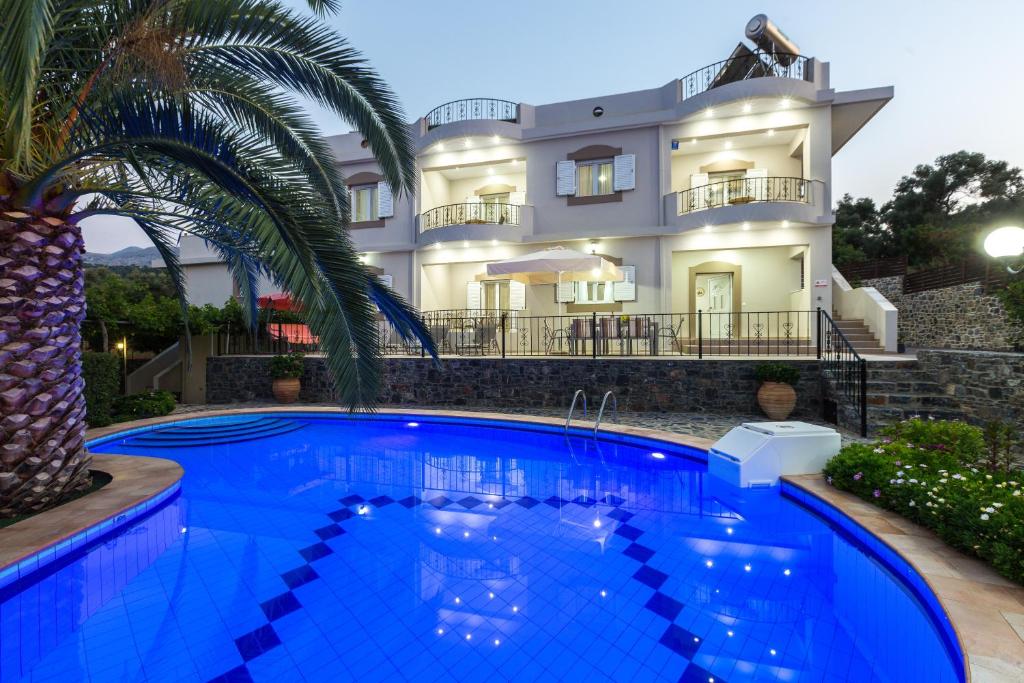 a villa with a swimming pool in front of a house at Villa Kamelia in Melissourgákion