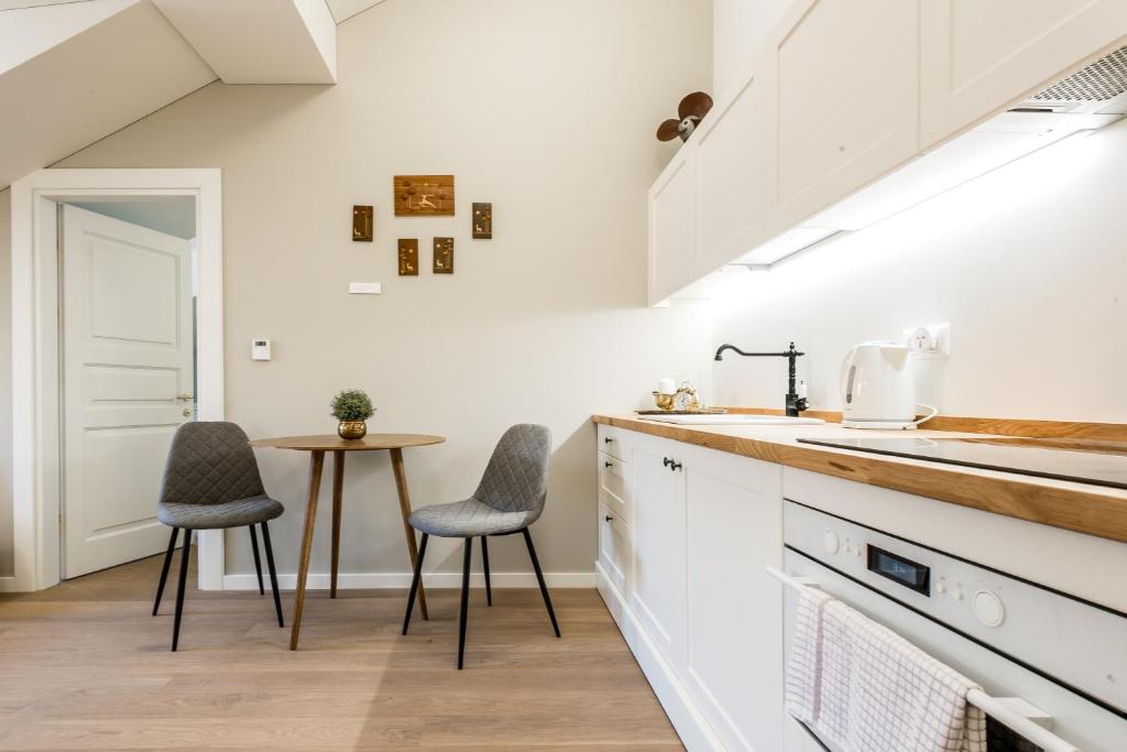 a kitchen with two chairs and a table at Angel House Vilnius 38 in Vilnius