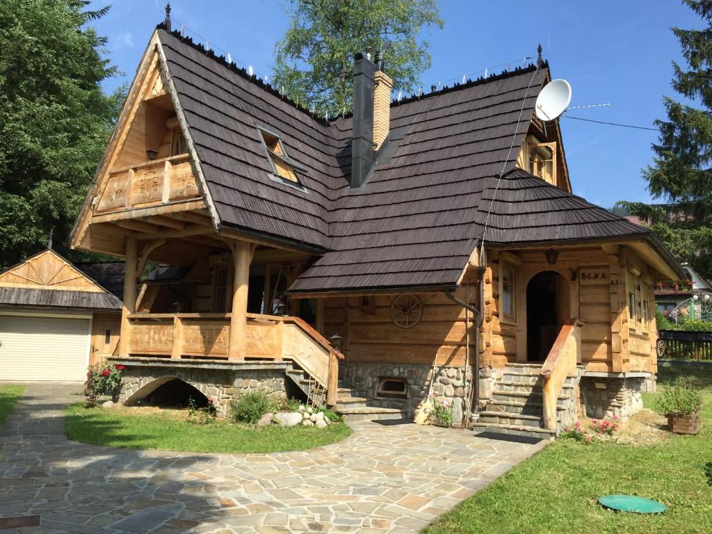 a large log cabin with a gambrel roof at Sweet Home Sweet APARTZAKOP in Kościelisko
