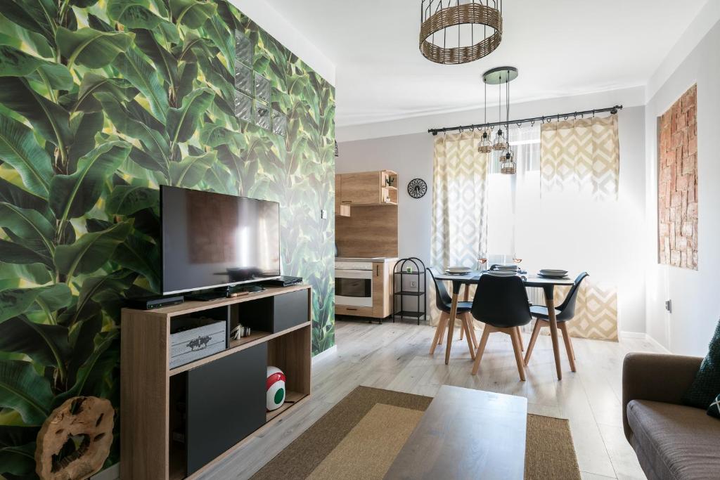 a living room with a large leafy wall at Csapô Apartment in Debrecen