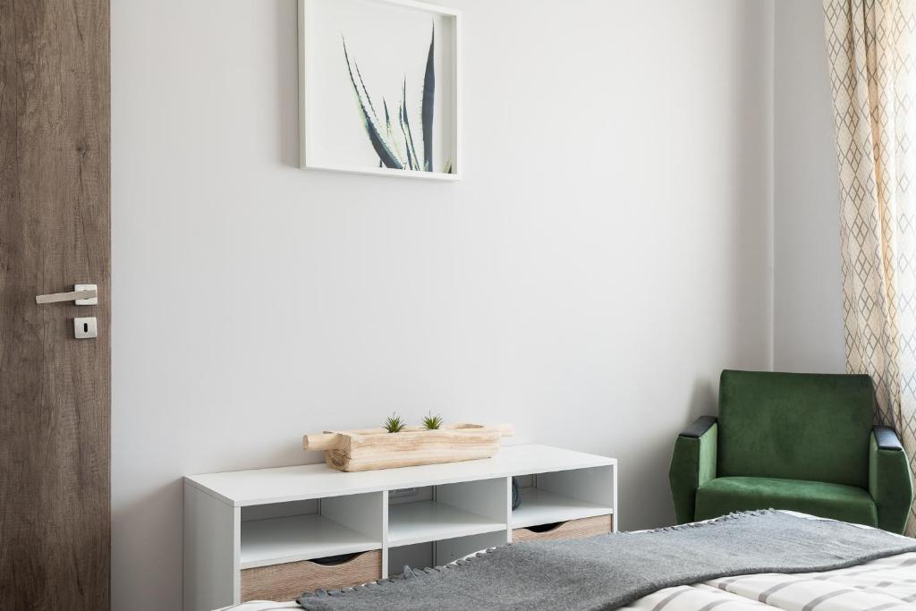 sypialnia z białym biurkiem i zielonym krzesłem w obiekcie Csapô Apartment w Debreczynie