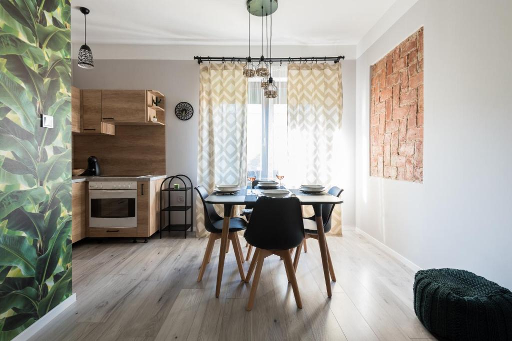 kuchnia i jadalnia ze stołem i krzesłami w obiekcie Csapô Apartment w Debreczynie