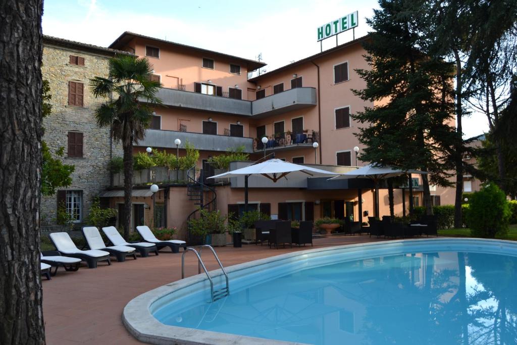 a hotel with a swimming pool in front of a building at Hotel Park Ge.Al. in Città di Castello