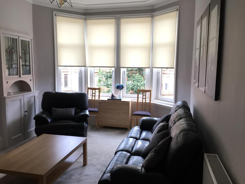 sala de estar con sofá, 2 sillas y ventanas en Apartment 2 Bed West End, en Glasgow