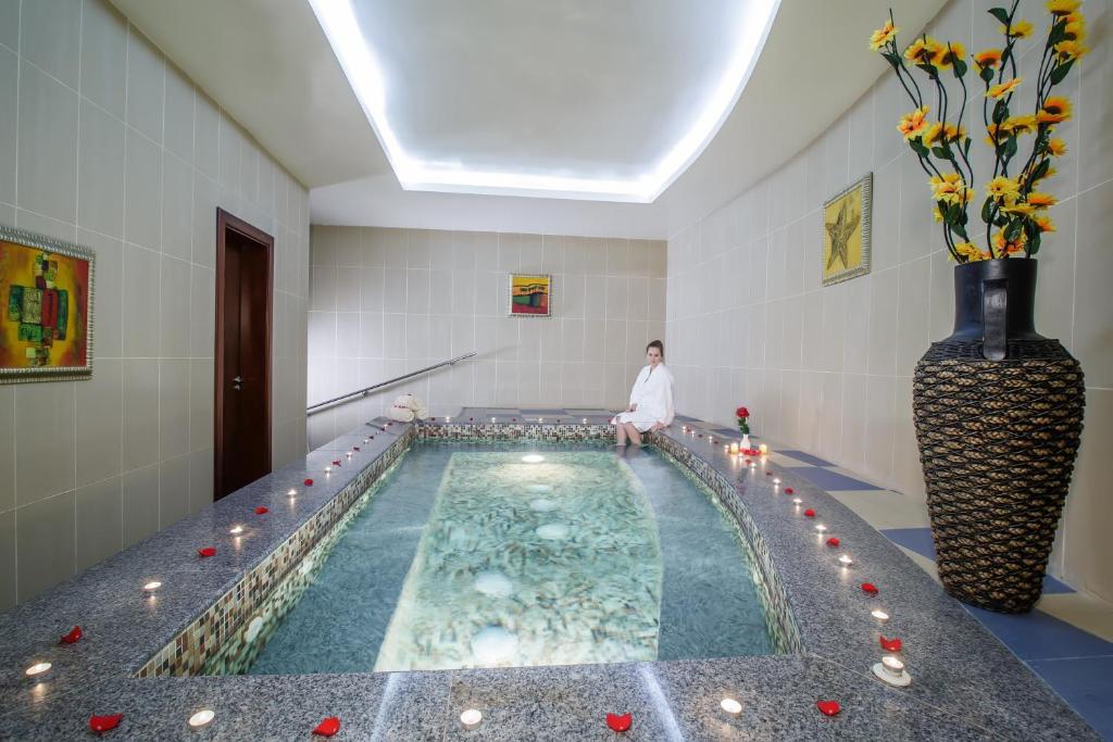 a woman standing in front of a swimming pool at Concorde Hotel Fujairah in Fujairah
