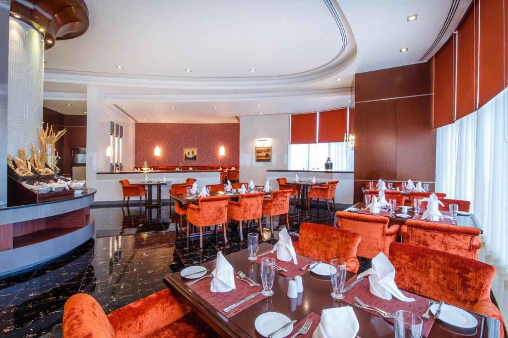 a restaurant with tables and chairs and a bar at Concorde Hotel Fujairah in Fujairah