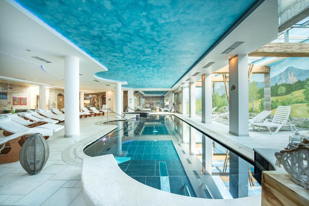einen Pool in einem Haus mit blauer Decke in der Unterkunft Hotel Alpenrose Wellness in Vattaro