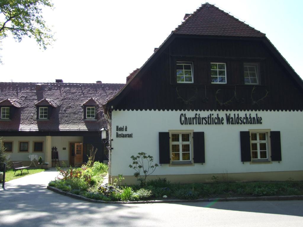 un bâtiment avec un panneau sur son côté dans l'établissement Churfuerstliche Waldschaenke, à Moritzburg
