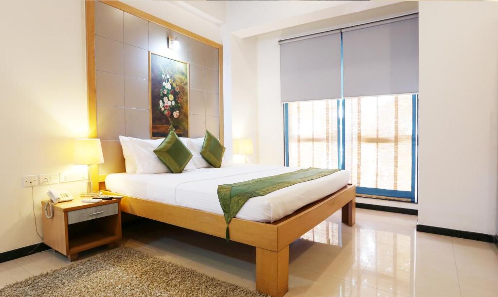 a bedroom with a bed and a large window at Treebo Trend Edha Suites Koramangala in Bangalore