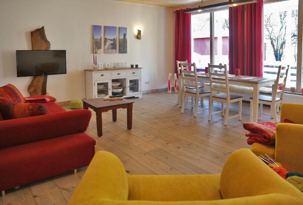 a living room with a table and a dining room at Ferienhaus-Rotdorn-Haus-Sued in Strukkamp auf Fehmarn