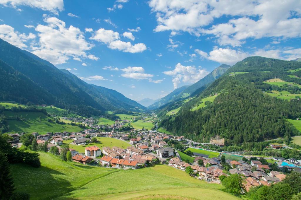 ein Dorf in einem Tal in den Bergen in der Unterkunft Das Bergland - Vital & Activity in St. Leonhard in Passeier