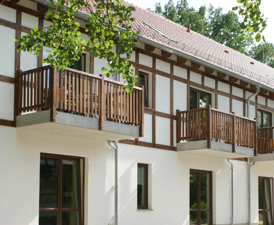 una casa con balconi in legno sulla facciata di Neue Mühle Kleines Landhotel a Brandenburg an der Havel