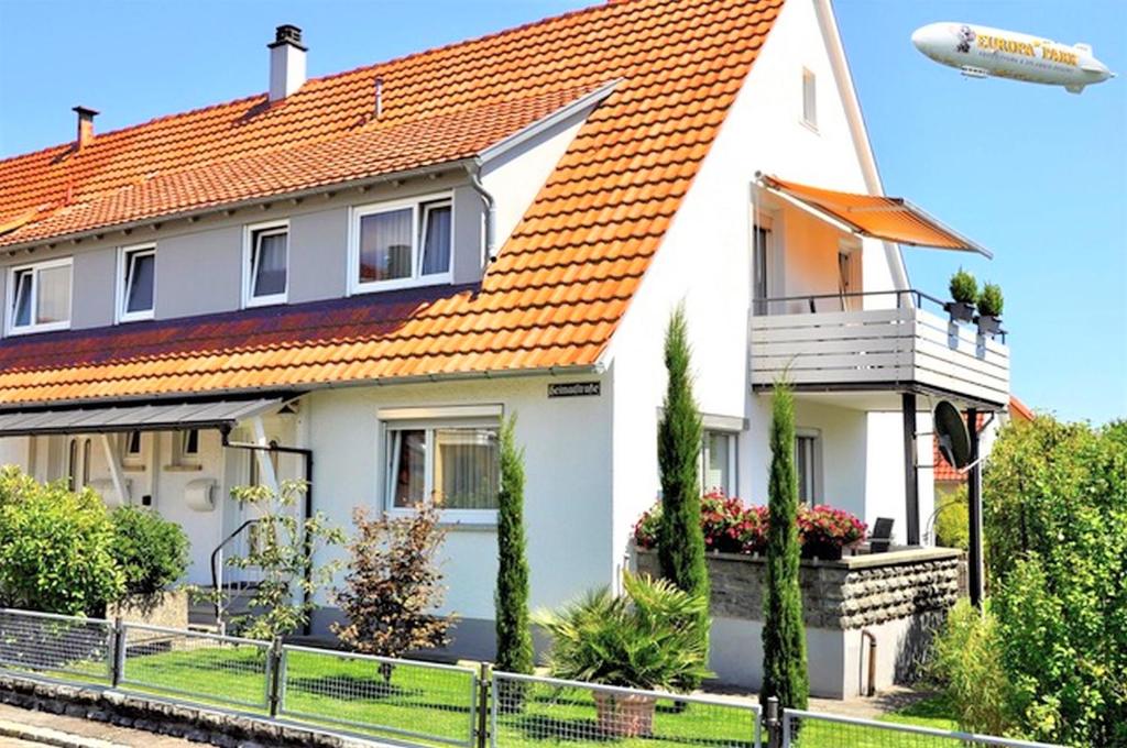 une maison blanche avec un toit orange dans l'établissement Ferienhaus Jäger, à Friedrichshafen