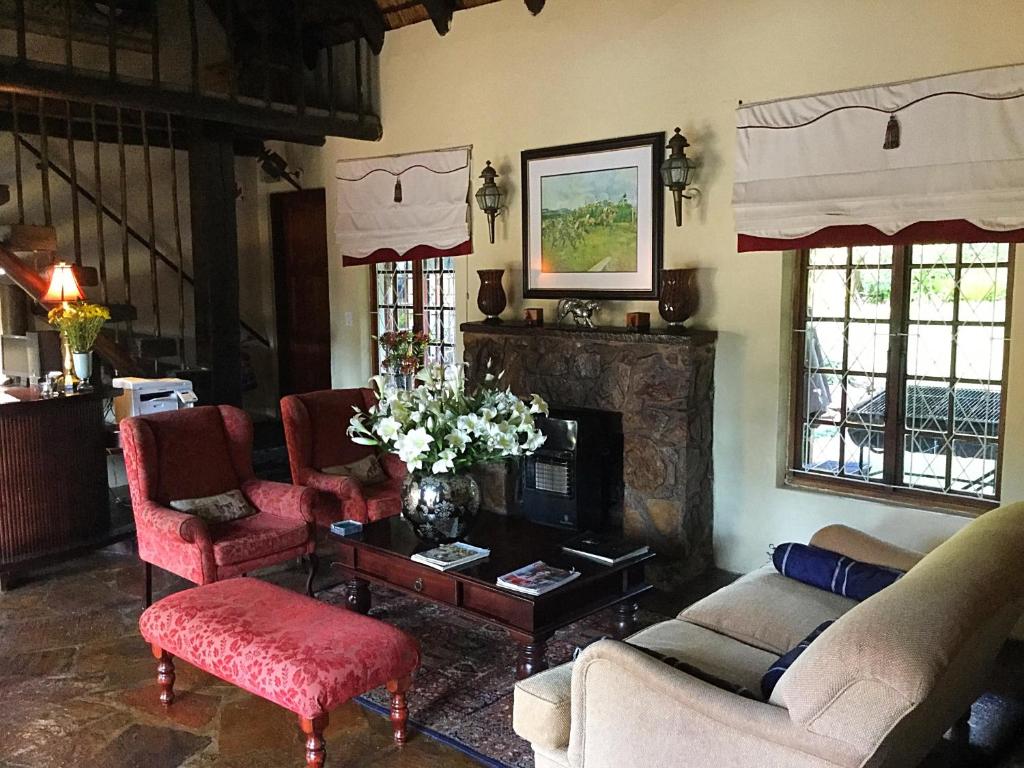 sala de estar con sofá, sillas y chimenea en Warrens Guest House, en Hillcrest