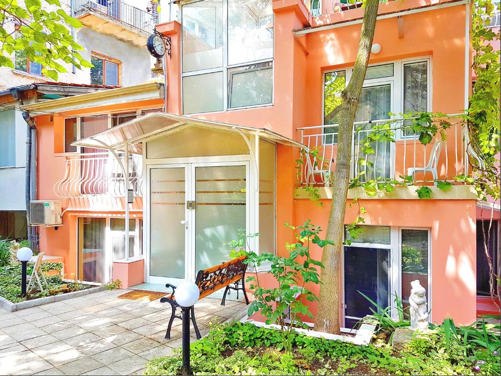 an orange building with a bench in front of it at YES Varna Studios in Varna City